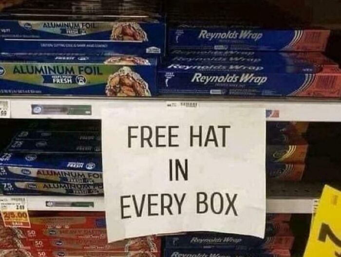 Store shelf with aluminum foil boxes and a sign reading free hat in every box for unhinged pics of people following instructions.