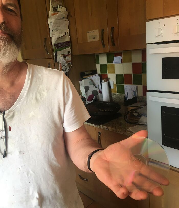 Man in a white shirt holding a transparent disc in his hand, illustrating unhinged people doing exactly what they were asked.