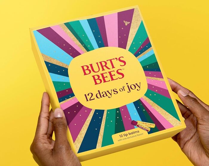 Colorful Burt's Bees advent calendar held by hands, featuring 12 days of lip balm joy for Christmas countdown.