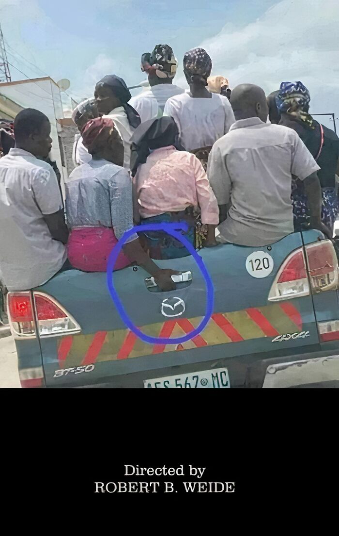 A group of people crowded in the back of a pickup truck, a hand awkwardly holding onto the tailgate in a frozen frame.