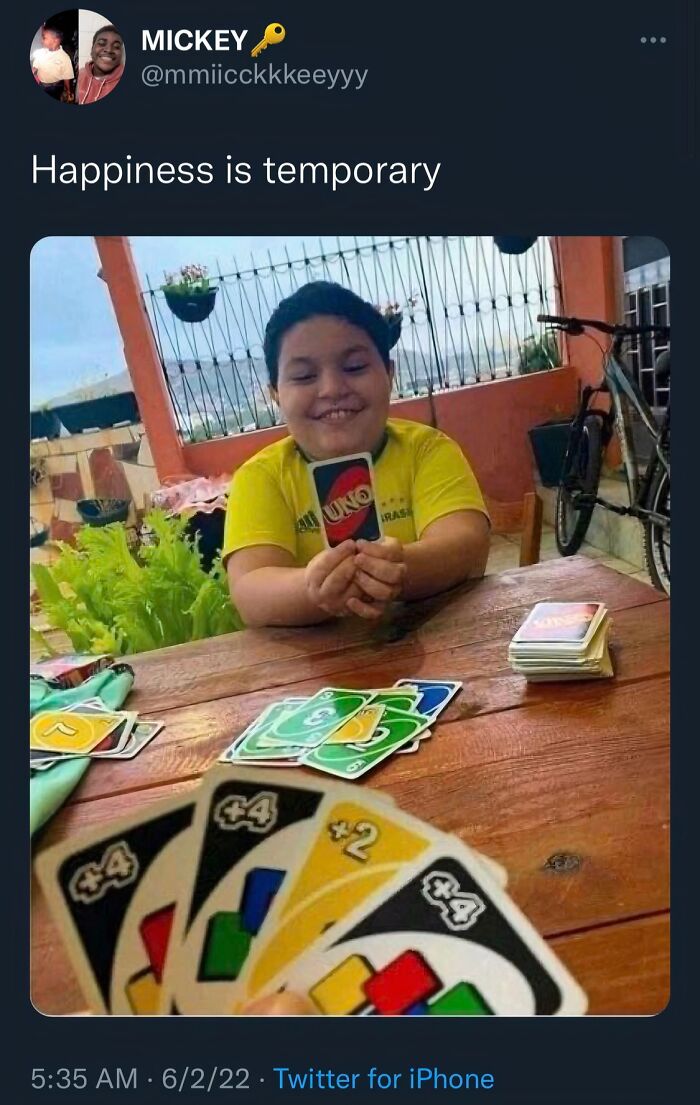 Child smiling while holding an Uno card during a game, capturing a frozen frame that tells emotion without showing aftermath
