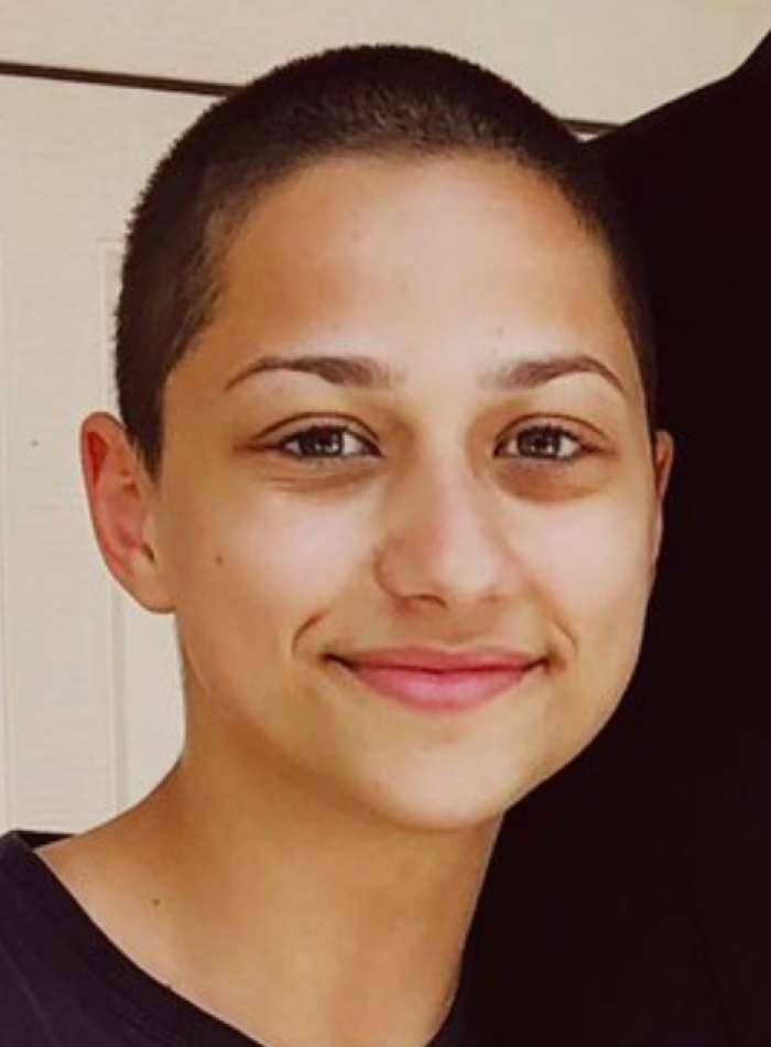 Close-up of X Gonz&aacute;lez smiling with a shaved head, showcasing a natural and confident look for bio and career highlights.