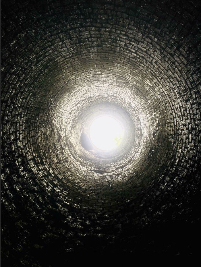 View looking up inside a cylindrical brick structure showing the intricate inside details of an object.