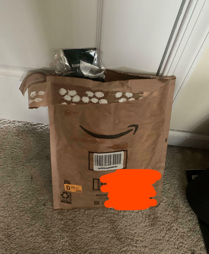 Torn Amazon package left on carpet in front of door, showing frustration with family members and online venting.