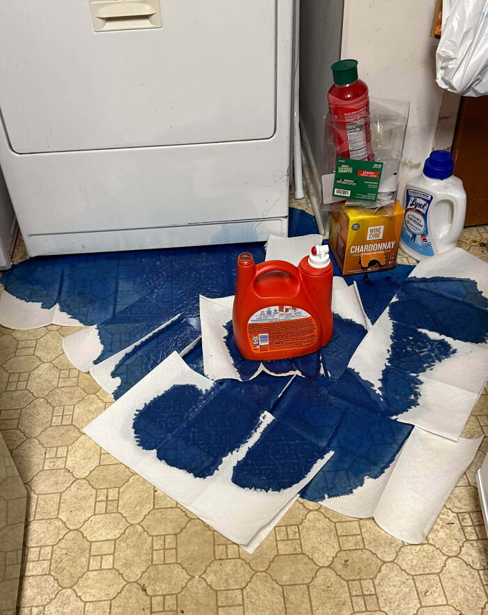 Laundry detergent spilled on the floor with paper towels soaking up the mess, showing family frustration vented online