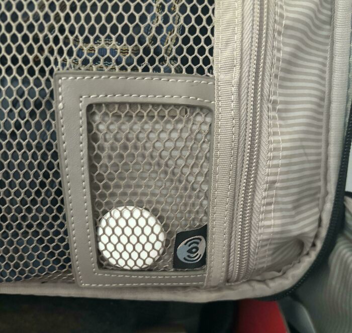 Small smart tracking device secured in a mesh pocket inside a travel bag, showcasing innovative problem-solving invention.