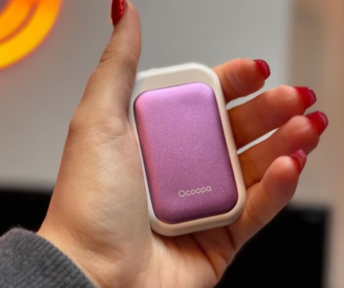 Hand holding a compact purple and white device, one of the burr basket goodies for hibernating until spring.