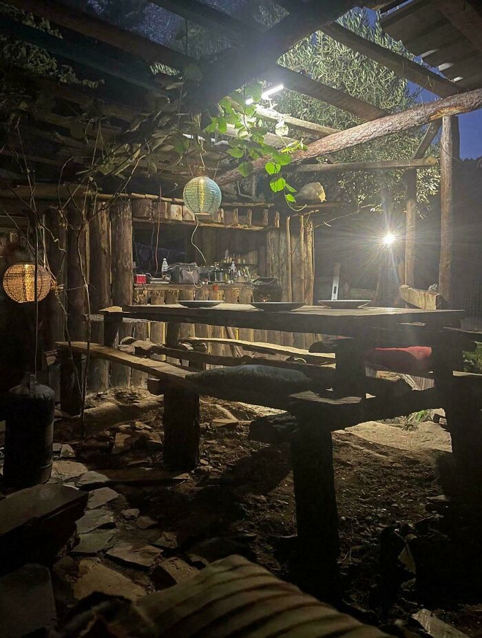 Cozy off-grid cabin interior at night with rustic wooden furniture, soft lighting, and natural elements for peaceful disconnect.
