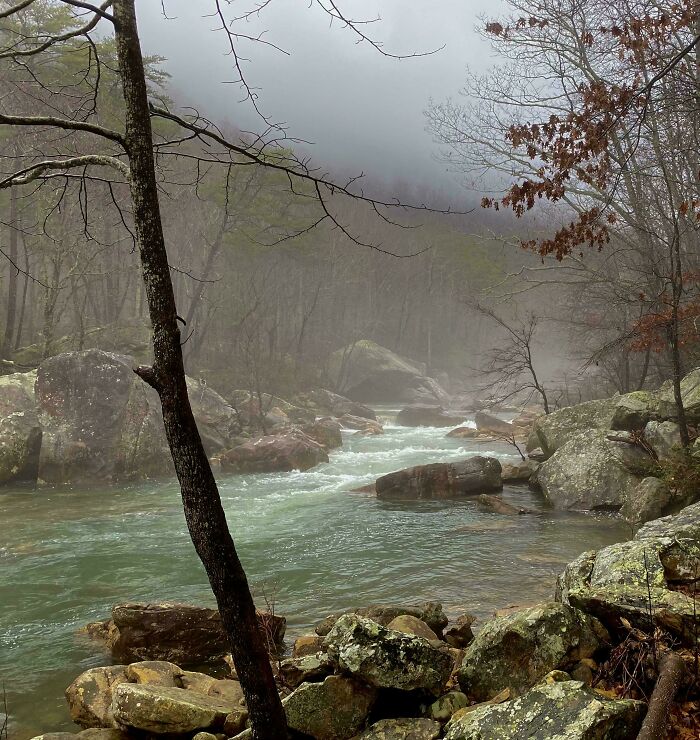 Misty river flowing through rocky forest landscape showcasing nature from a completely different perspective.