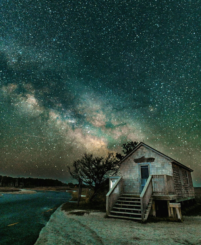 Night sky filled with stars over a small rustic house, showcasing amazing pics of our world from a different perspective.