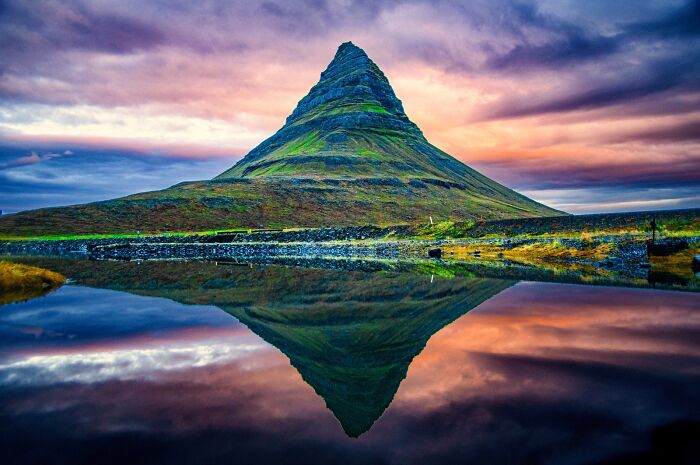 Mountain reflected in still water at sunset, showcasing amazing pics that reveal our world from a different perspective.