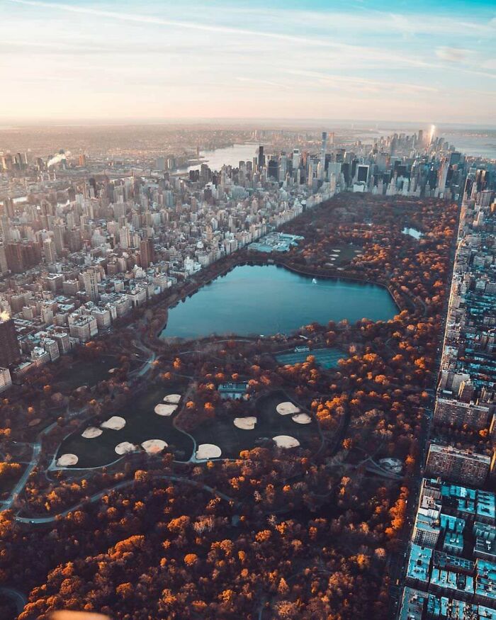 Aerial view of a cityscape with a large park and lake, showcasing an amazing perspective of our world from above.