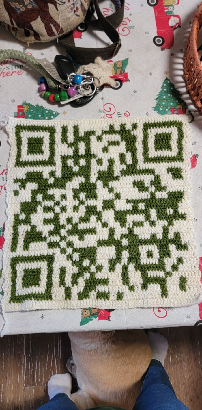 Crochet enthusiasts proudly share detailed green and white crocheted QR code project on festive table setting.