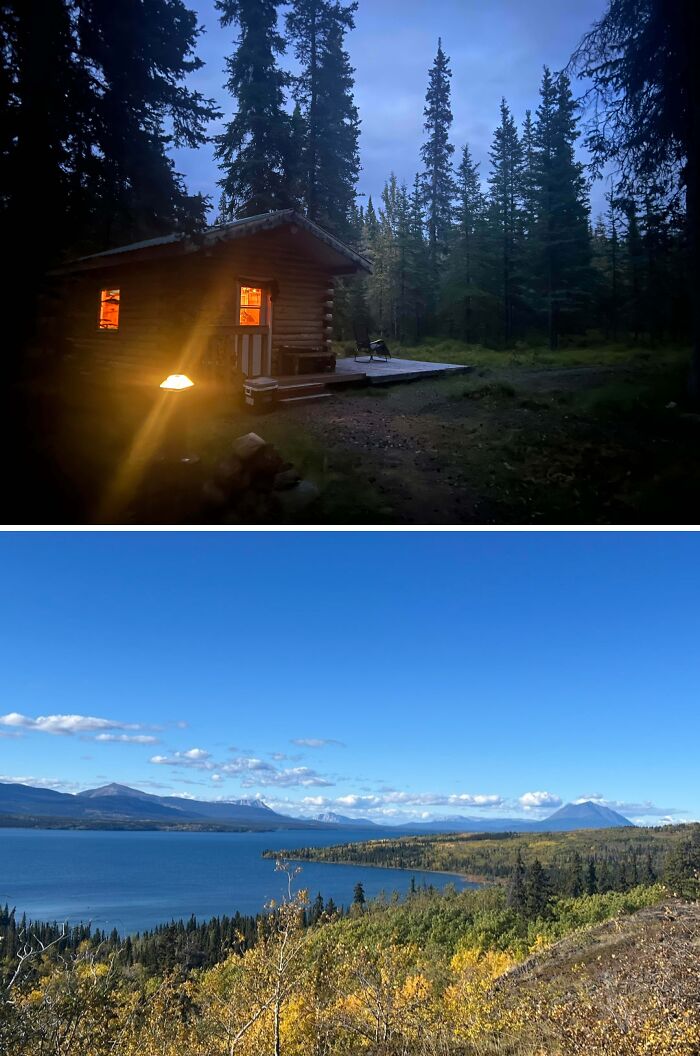 Cozy off-grid cabin glowing warmly at dusk surrounded by trees, paired with scenic lake and mountain landscape under blue sky.