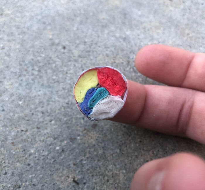 Close-up of the colorful cross section showing the insides of an electrical cable on a fingertip detail.