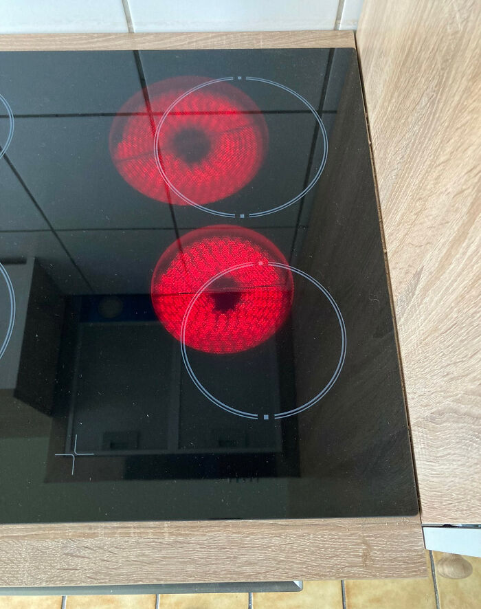 Electric stovetop with two burners turned on, showcasing a funny example of people not even trying to cook properly.