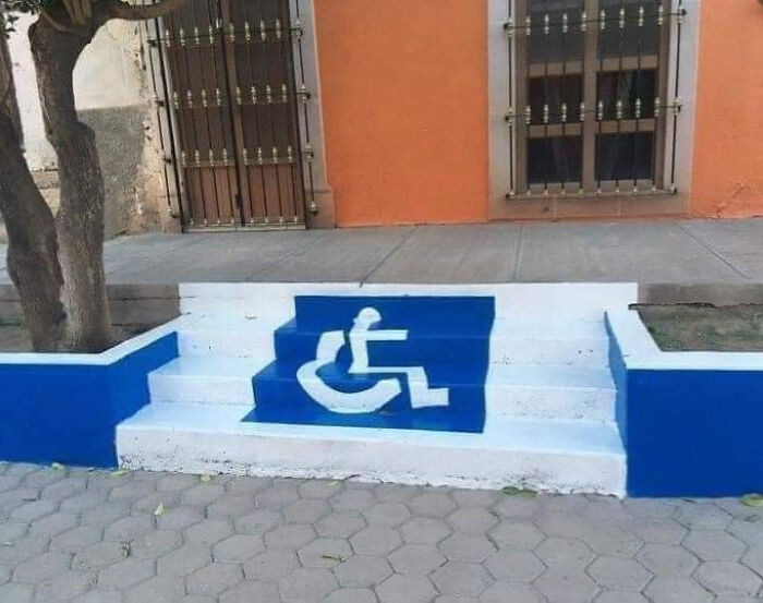 Stairs painted with a wheelchair accessibility symbol, highlighting a funny example of people not even trying.