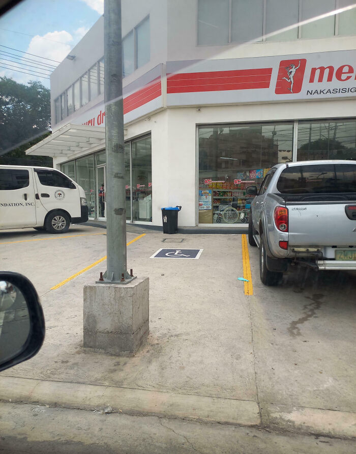 Handicap parking space blocked by a concrete pole, a funny example of people not even trying to follow rules.