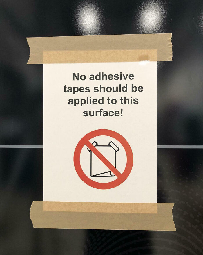 Sign warning no adhesive tapes on surface, humorously ignored with tape, showing people not even trying with funny job fails.