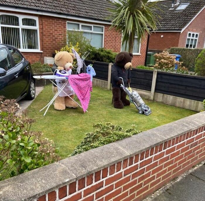 Two large teddy bears doing household chores in a front yard, depicting relatable life moments for students and young adults.