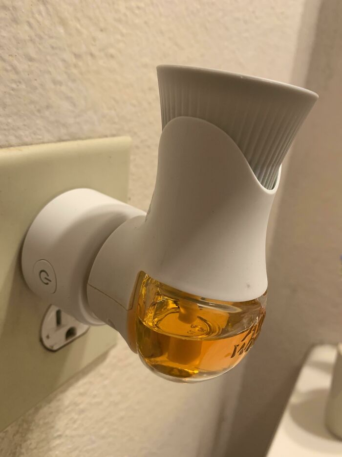 Plug-in air freshener with amber liquid designed to solve odor problems in small indoor spaces effectively.