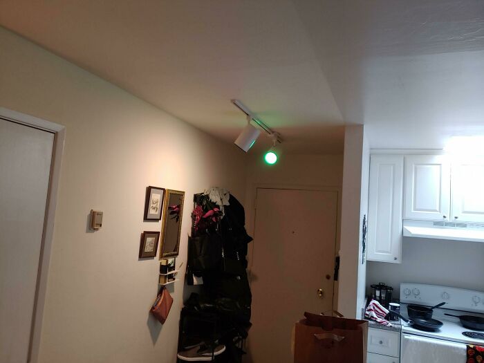 Entryway with smart lighting invention using a green indicator light above the door to signal status.