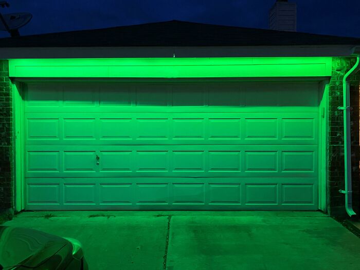 Garage door illuminated with green LED lights as a smart invention solving outdoor safety and visibility problems.