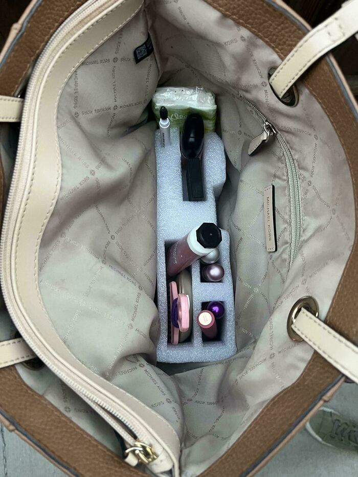 Organized handbag with foam compartments holding makeup items demonstrating smart ideas and inventions solving storage problems.