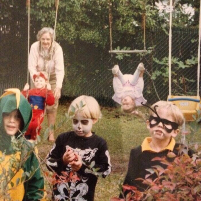 Kids in Halloween costumes in a backyard with a girl upside down on a swing, a classic epic photobomb that stole the show.