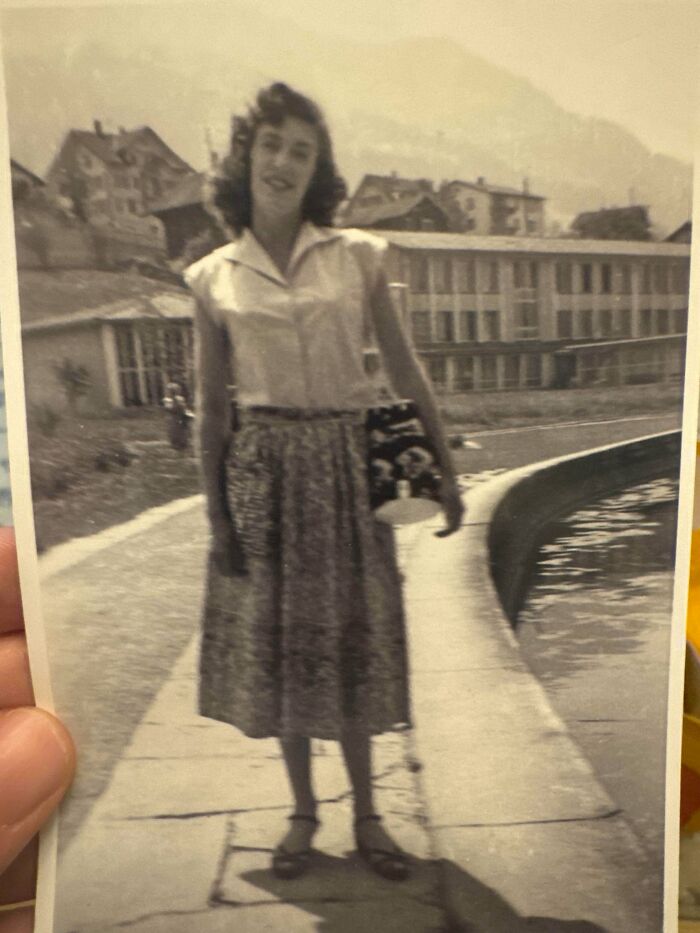 Vintage black and white photo of a woman standing on a sidewalk near water, part of where was this taken posts.