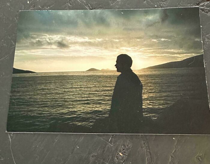 Silhouette of a person by the ocean at sunset in a serene scene perfect for where was this taken posts.