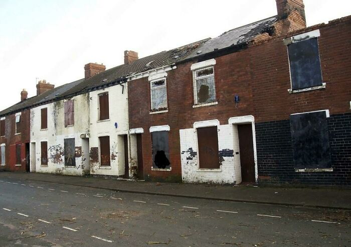 Row of abandoned brick houses with boarded-up windows and doors, featured in where was this taken internet posts.