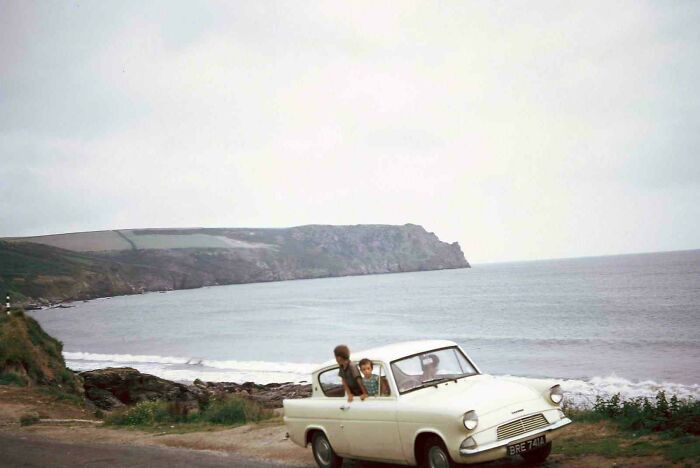 Two children in a vintage car near the coast with cliffs in the background where was this taken scene.