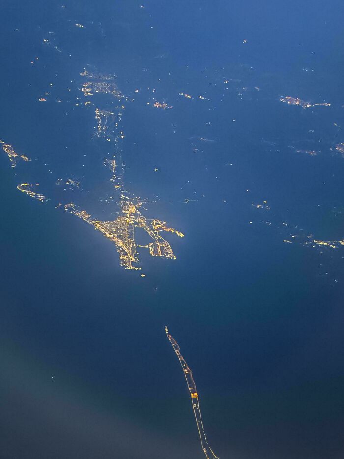 Aerial night view of a coastal city with illuminated streets and bridges, illustrating where was this taken internet posts.