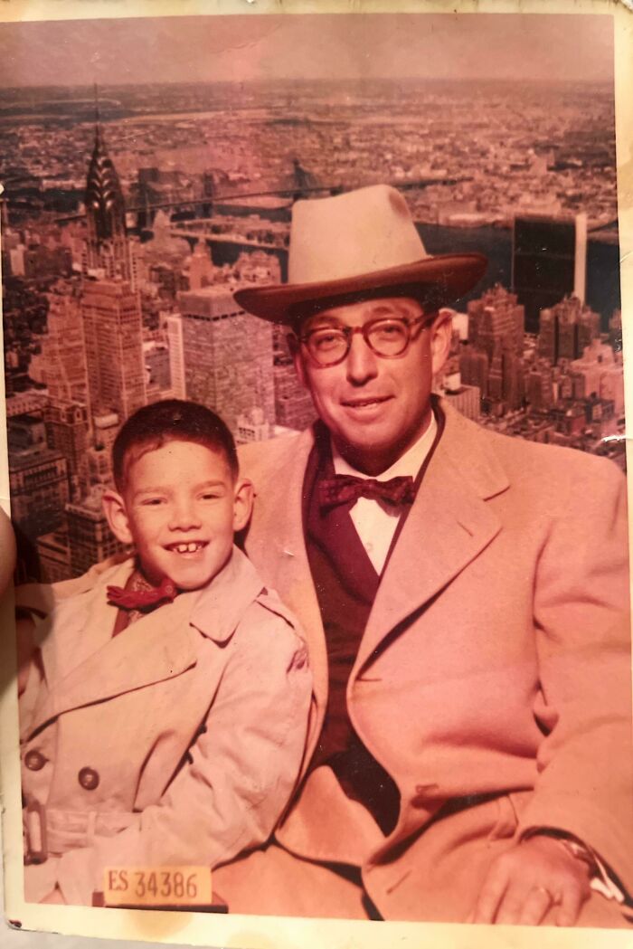 Vintage photo of a man and boy in coats and bow ties posing with a city skyline backdrop for where was this taken posts.