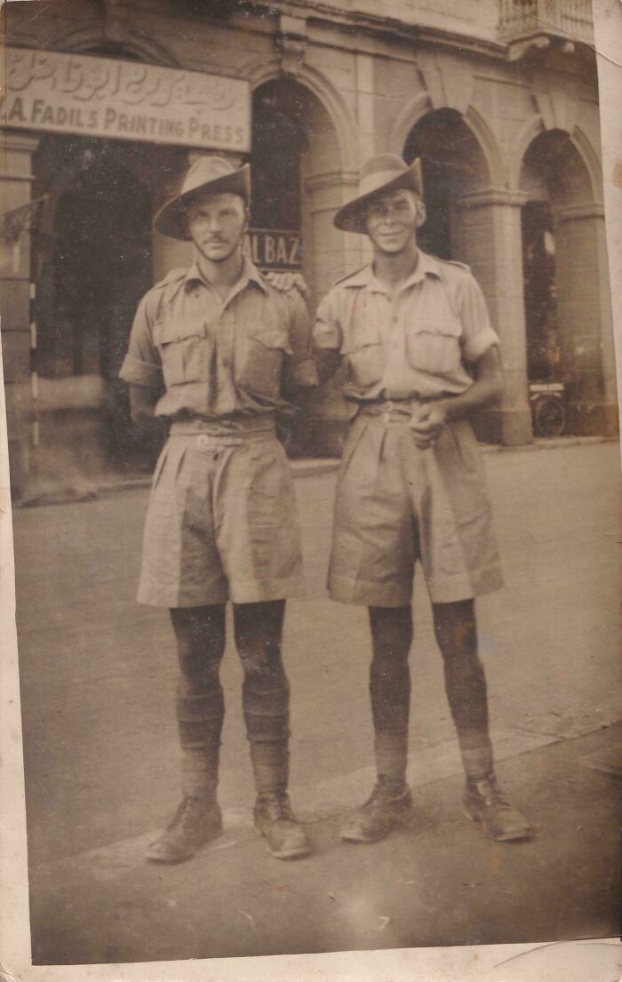 Two soldiers in vintage uniforms posing on a street, part of a where was this taken post showing historical locations.
