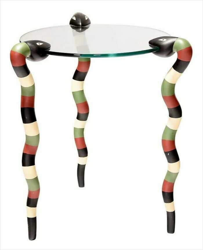 Glass table with colorful snake-shaped legs, showcasing very old objects that survived to tell stories about ancestors.