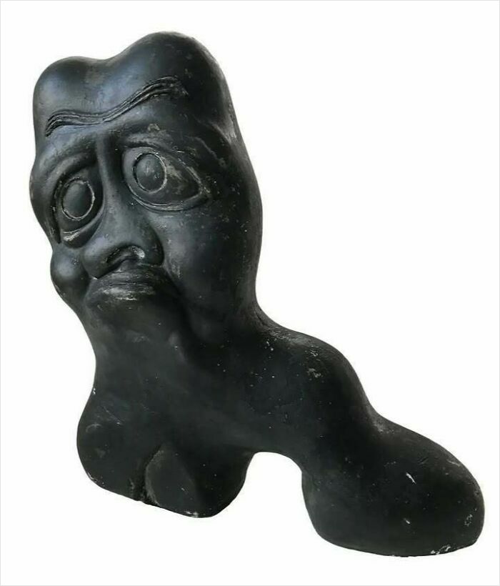 Black ancient carved stone figure with exaggerated facial features, one of the very old objects showing stories of ancestors.