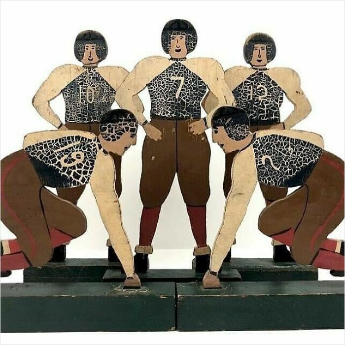 Wooden vintage football game figurines showing very old objects that survived from ancestors with numbered jerseys.