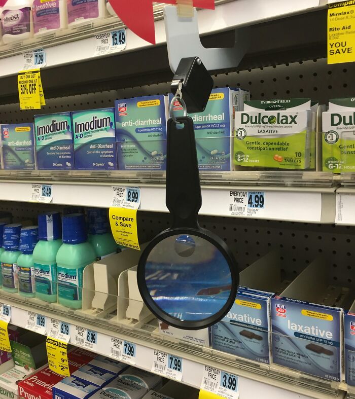Security mirror hanging on store shelf with anti-diarrheal and laxative products, showcasing smart ideas and inventions.