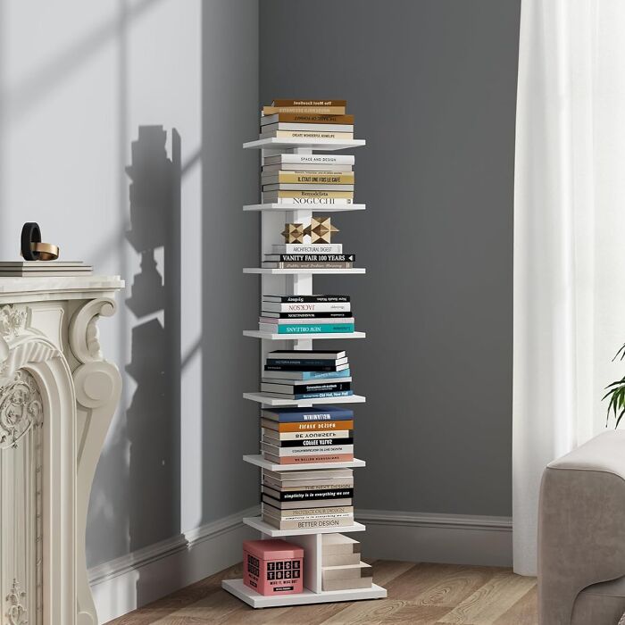 Tall white bookshelf filled with books in a cozy living room, enhancing a warm and inviting house feel.