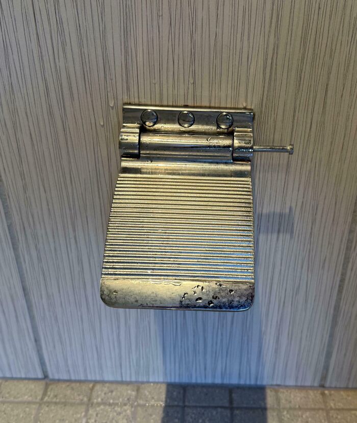 Metal foot pedal with ridged surface attached to a door, an inventive solution to hands-free door opening ideas and inventions.