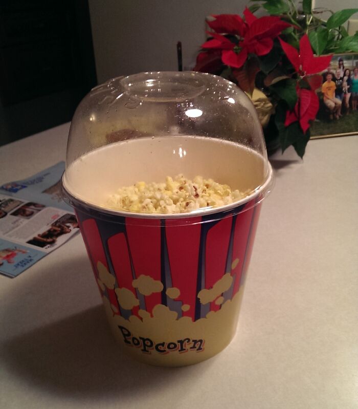 Popcorn container with a clear dome lid that serves as a bowl, showcasing a smart idea and invention solving a problem.