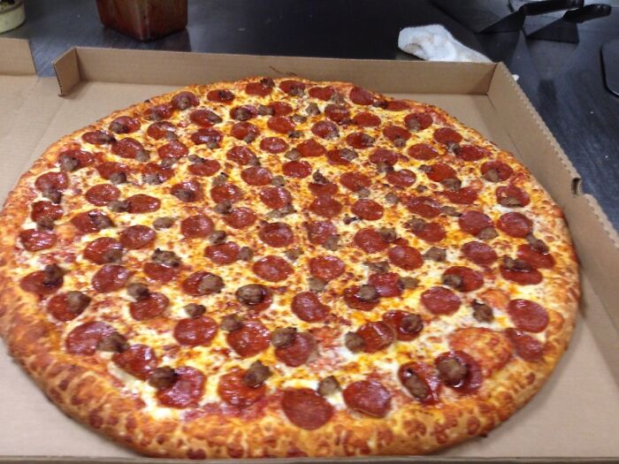 Large pepperoni pizza fresh in an open box showcasing a crispy crust and melted cheese, illustrating food complaints humor.