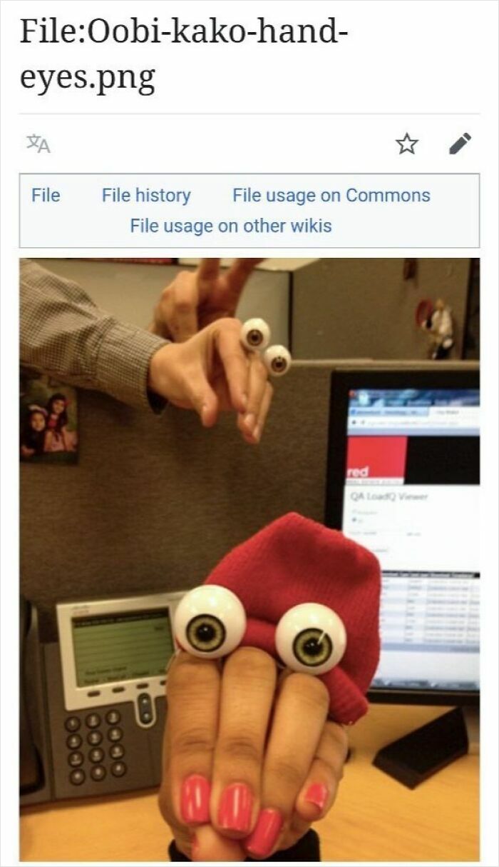 Hand puppets with fake eyes on fingers creating funny characters in an office setting from c*****d Wikipedia pages online.