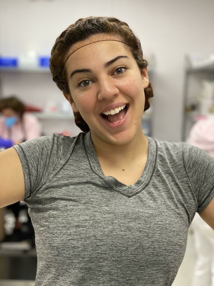 Young woman smiling excitedly, showcasing the joy of turning dreams into reality and inspiring the internet.