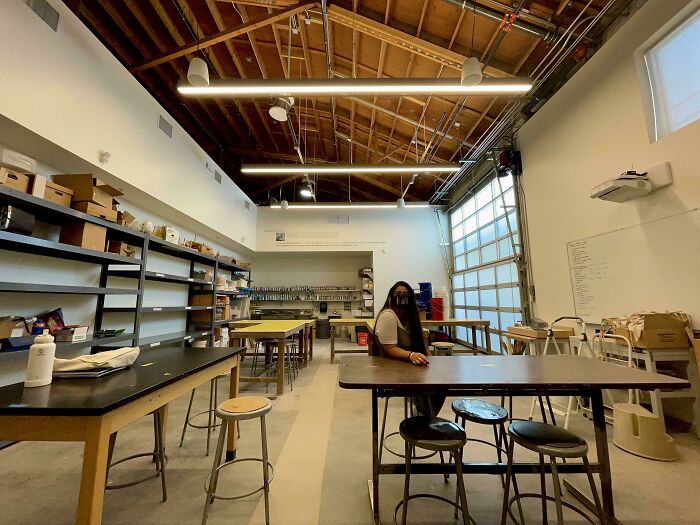 Person sitting at a table in a creative workspace, turning dreams into reality and inspiring the internet with their work.