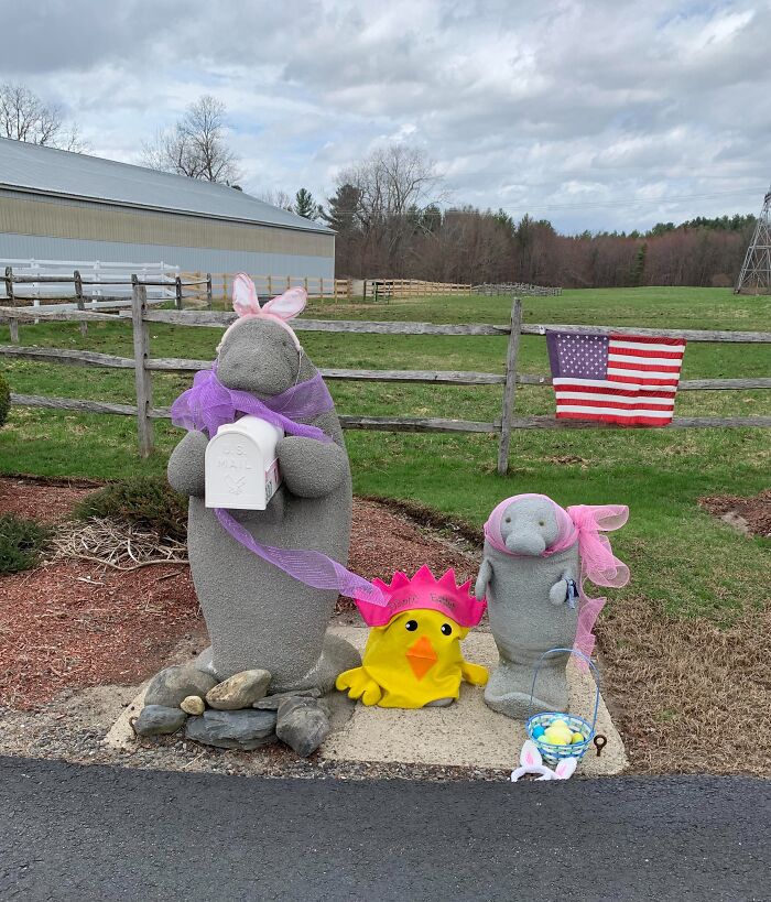 Creative and cool mailbox designed as a gray manatee figure with Easter decorations on a rural roadside.