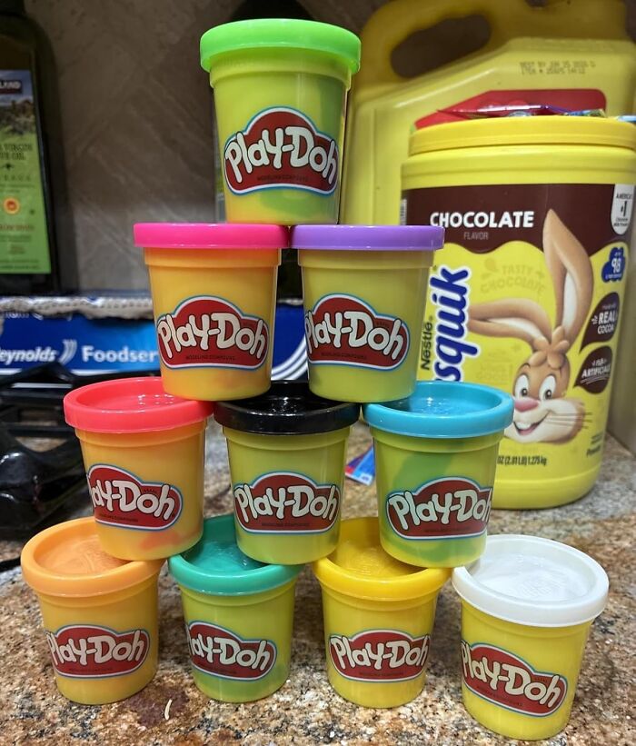 Stacked colorful Play-Doh containers on kitchen counter, a fun and creative stocking stuffer idea for holiday gifts.