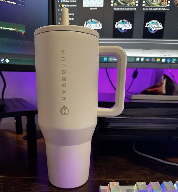 HydroJug water bottle on desk with computer monitors in the background, a great stocking stuffer gift idea.